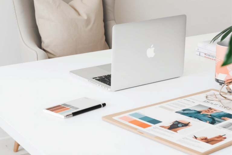 Laptop auf einem Tisch mit Kuli und Branding Moodboard
